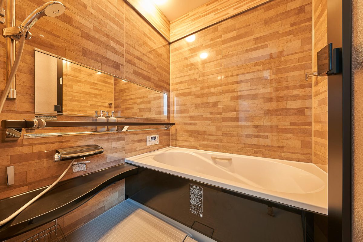 Bathtub and shower area with wood-tone wall panels